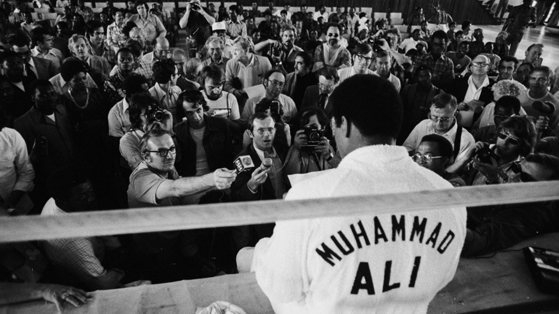 Muhammed Ali Clay'in gazetecilerle konuşurken arkadan çekilmiş görseli.