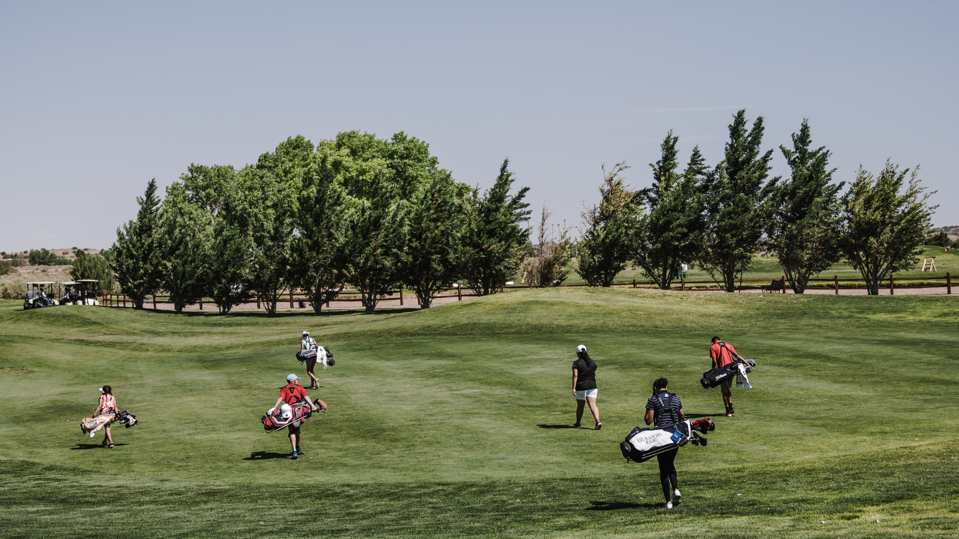 Golf sahasında yürüyen golfçülere ait görsel.
