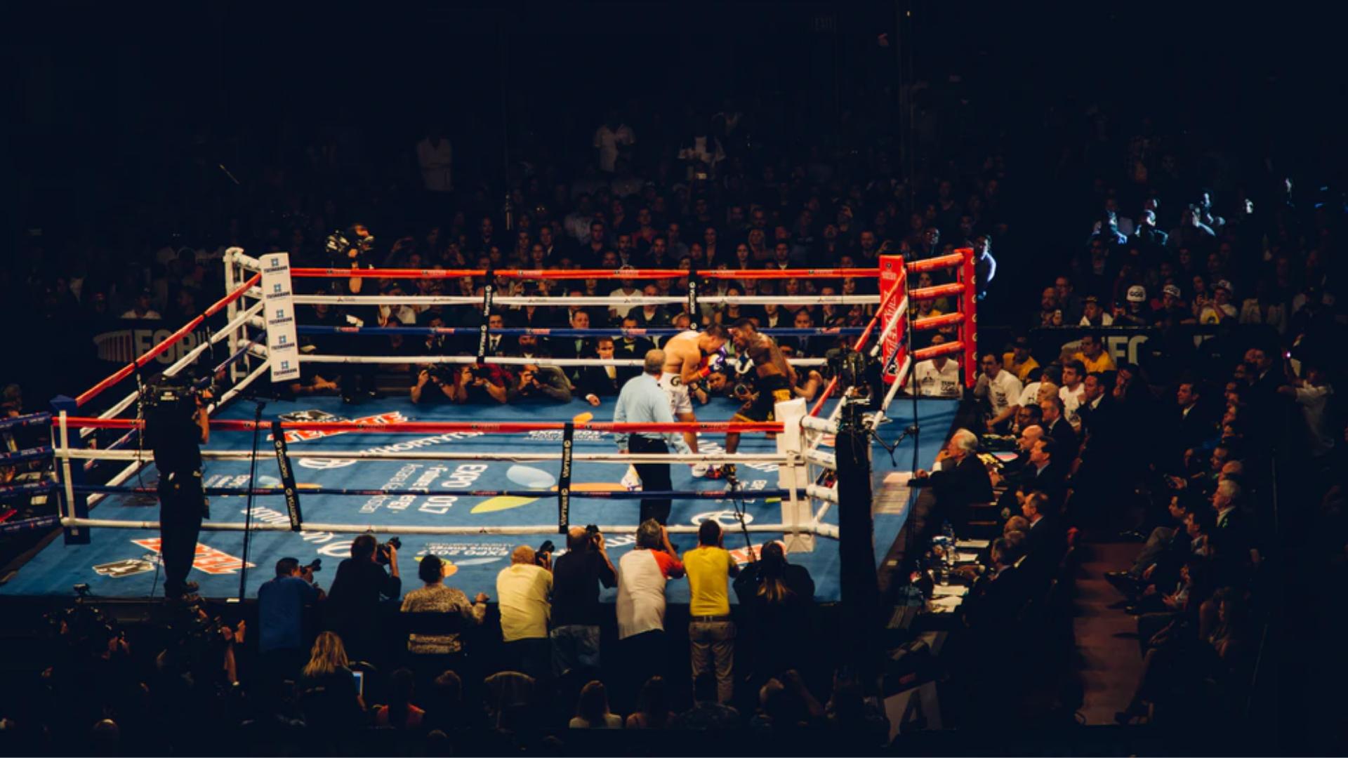 Boks ringi içinde iki boksörün yaptığı dövüşe ait bir görsel.